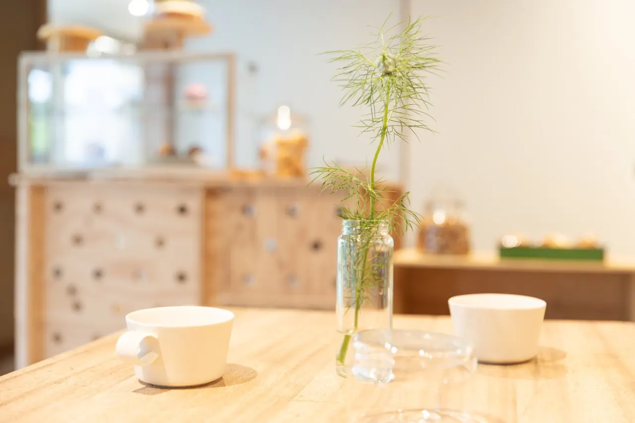 カフェスペースのテーブルにあるカップと植物