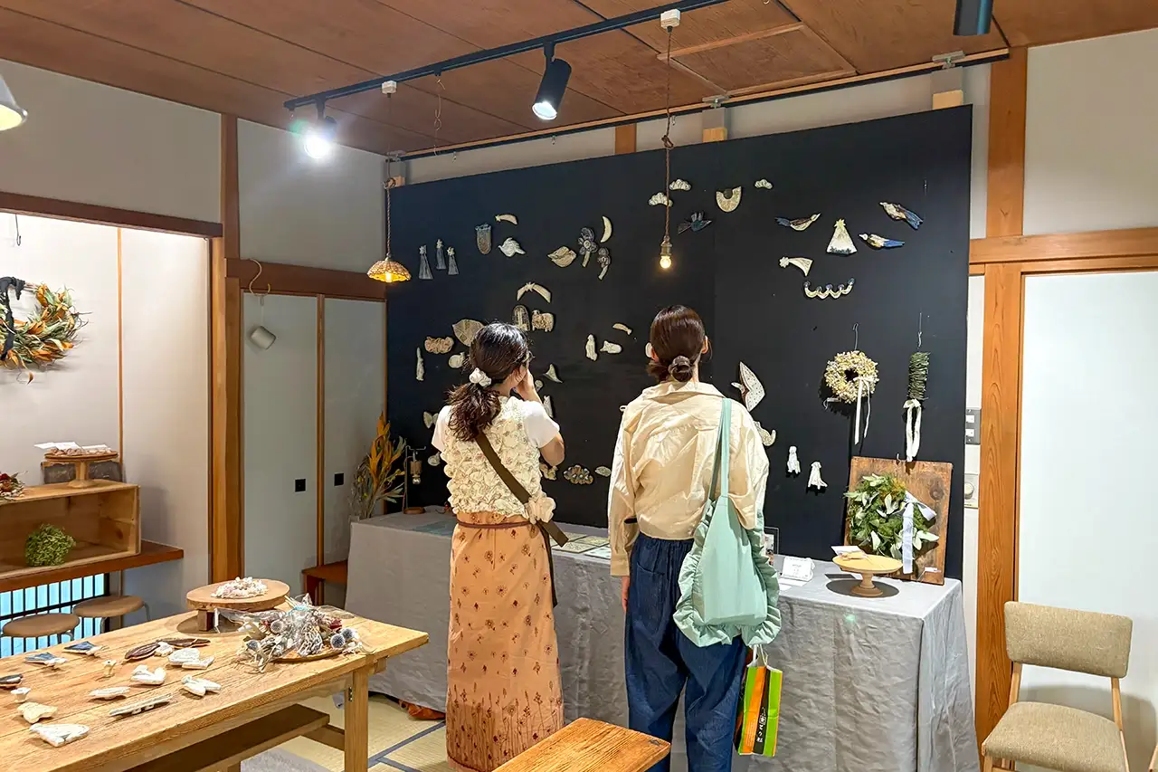 和室のレンタルスペースで作品展示を見る女性たち